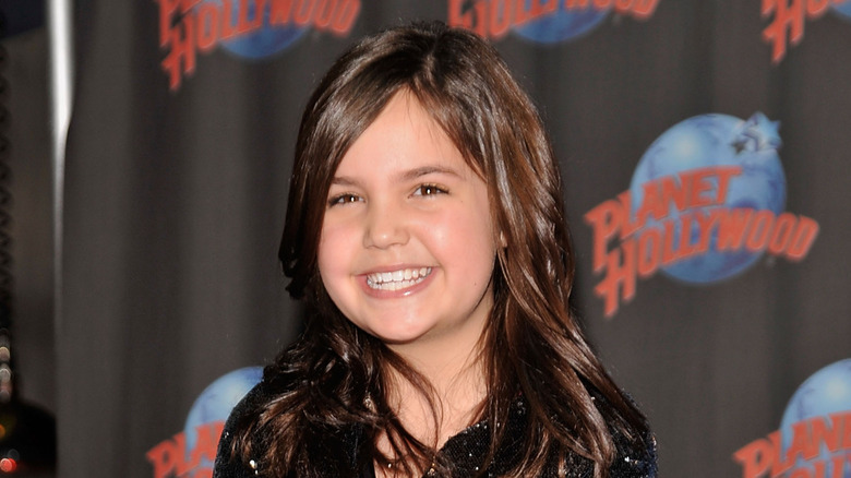 Young Bailee Madison with a wide smile and long hair