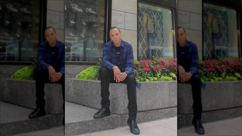 Russy Simmons posing outside of a building