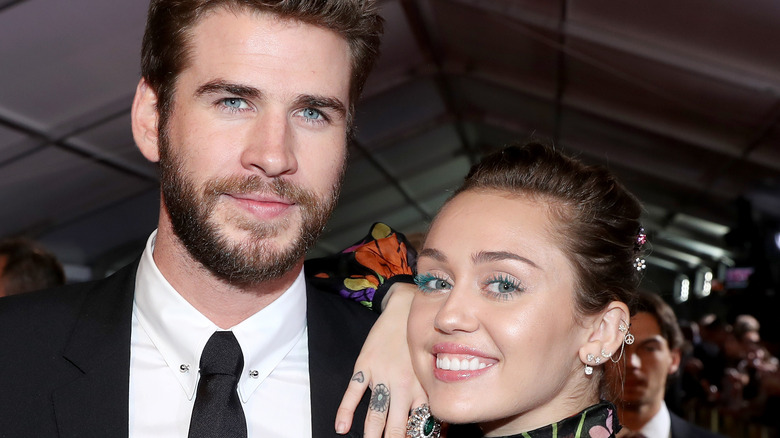 Miley Cyrus and Liam Hemsworth pose on the red carpet