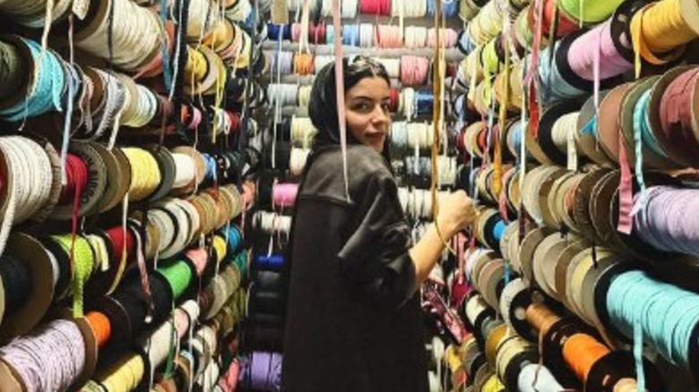 Candice Cuoco posing among colorful spools of thread in 2026.