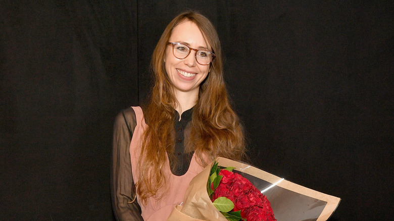 Leanne Marshall smiling with a bouquet of flowers at 2018 New York Fashion Week.
