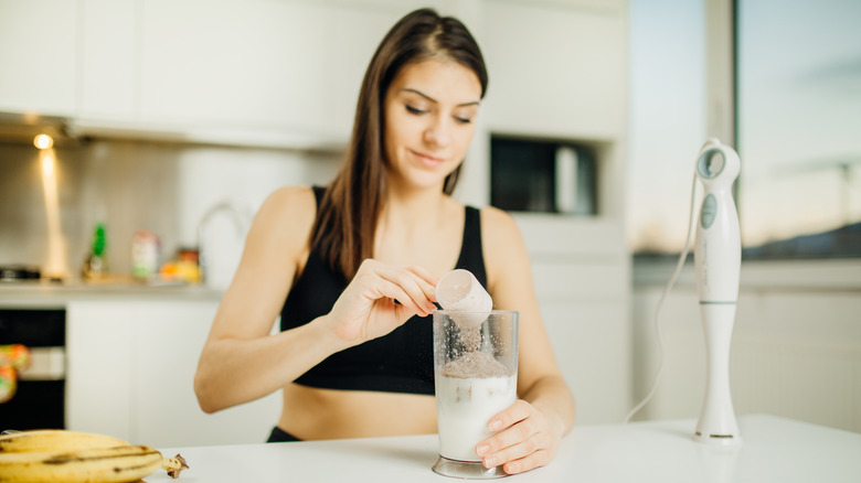 Fit woman preparing a whey protein shake