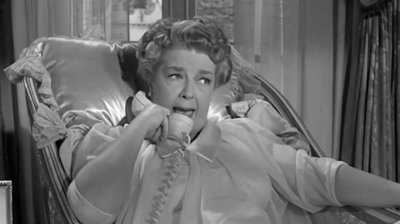 Harriet MacGibbon as Mrs. Margaret Drysdale in "The Beverly Hillbillies" lays in a chair on the phone wearing a nightgown