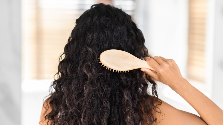 Woman brushing curly hair