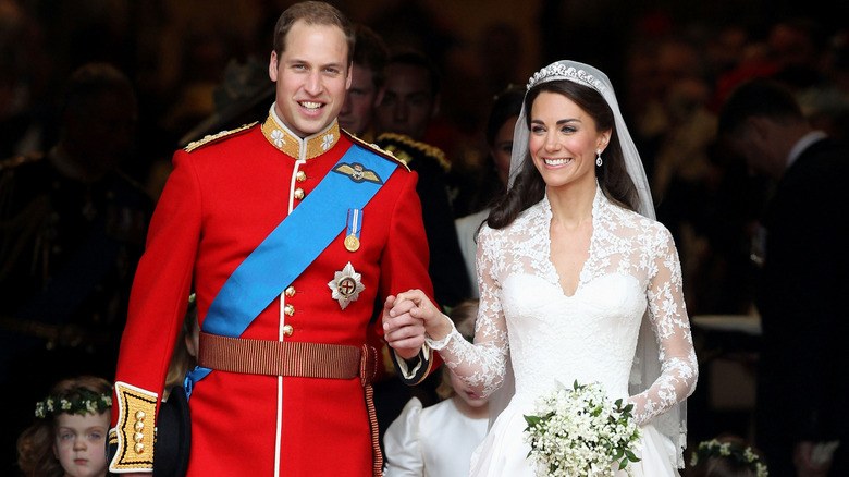 Prince William and Princess Catherine smiling while holding hands on their wedding day