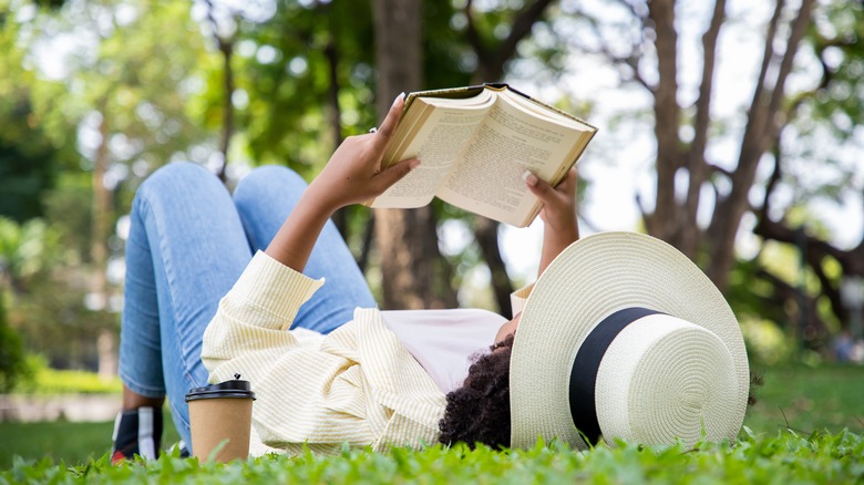 Woman reading book in grass