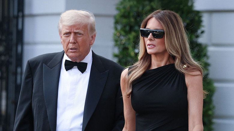 Donald and Melania Trump walking outside together in black-tie attire