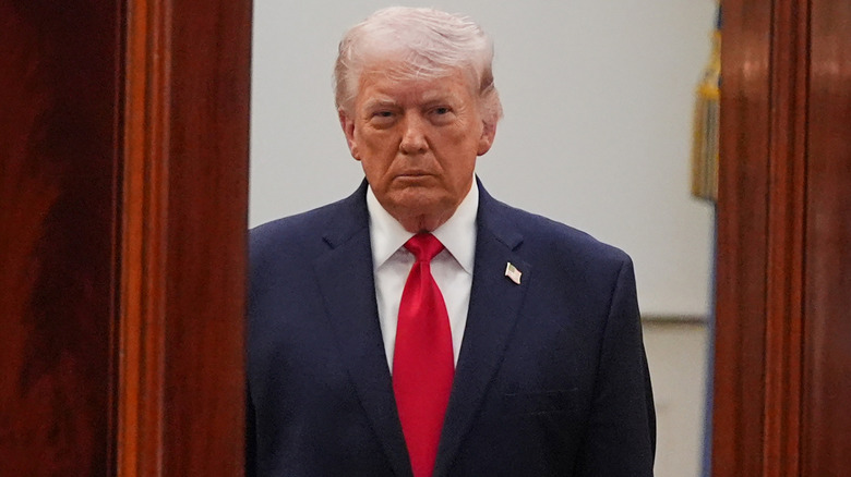 Donald Trump looking grim standing in doorway