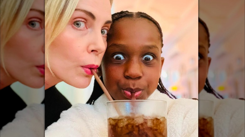 Charlize Theron sipping a Coke with her daughter