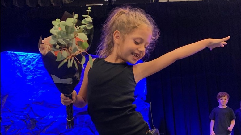 Callaway Lane Ross-Faulkner holding a bouquet of roses and striking a pose
