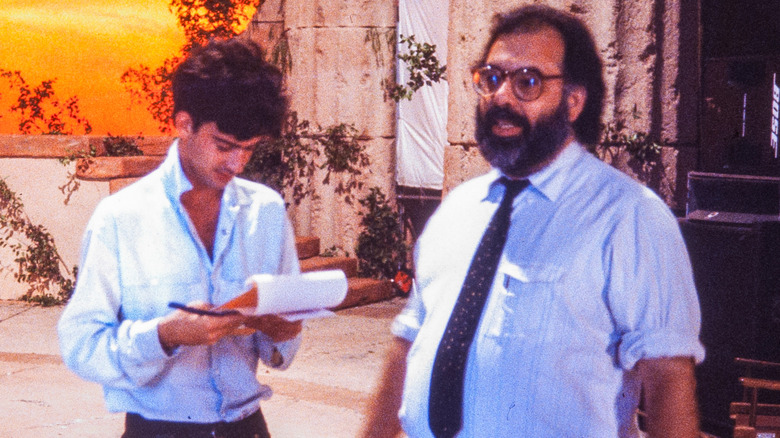 Gian-Carlo Coppola looking at a notepad and standing next to Francis Ford Coppola