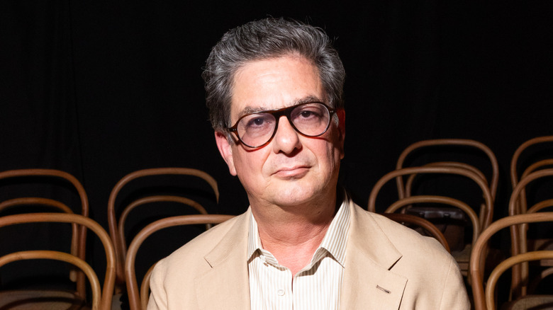 Roman Coppola in a dark room of empty chairs