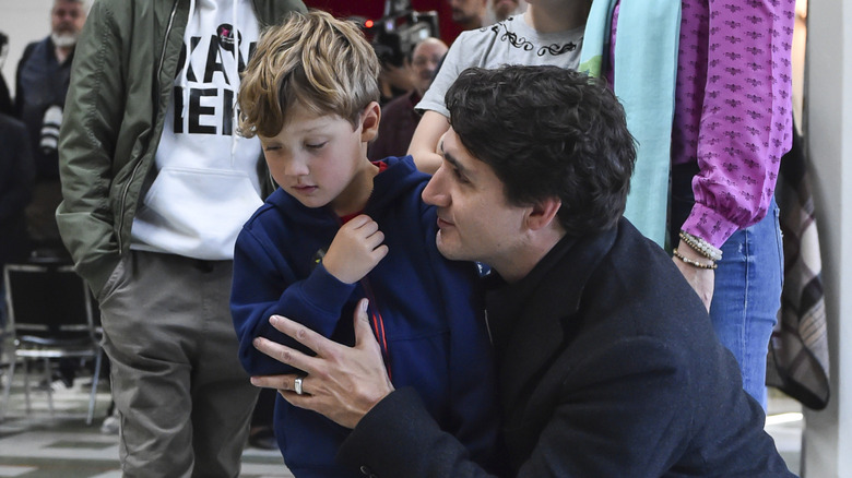 Justin Trudeau holds his son Hadrien Trudeau comforting him as he looks away from the camera
