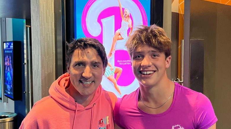 Justin Trudeau and his son Xavier Trudeau smile wearing pink in front of a Barbie movie poster