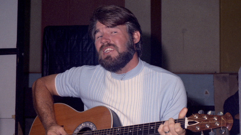 Kenny Rogers playing guitar in the 1960s