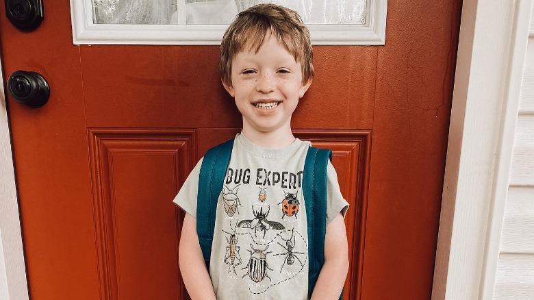 Axel Brush smiling against door