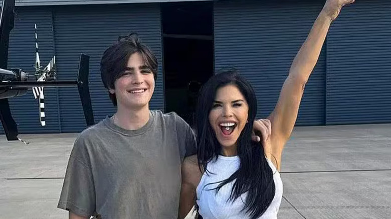 Evan Whitesell arm around Lauren Sánchez who has one arm raised