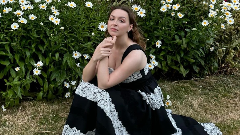 Zenouska Mowatt posing in a garden surrounded by flowers