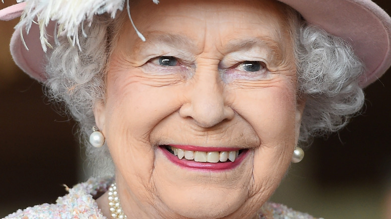 Queen Elizabeth II smiling in pink