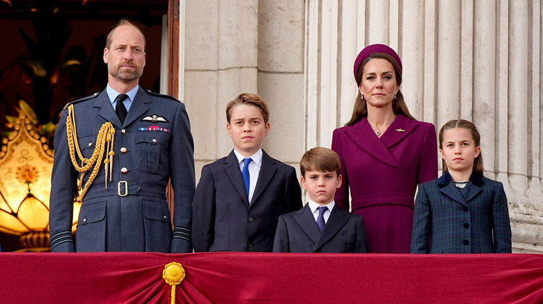 The Prince and Princess of Wales and children standing on balcony