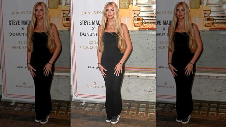Princess Andre in long black dress with sneakers and long blonde hair