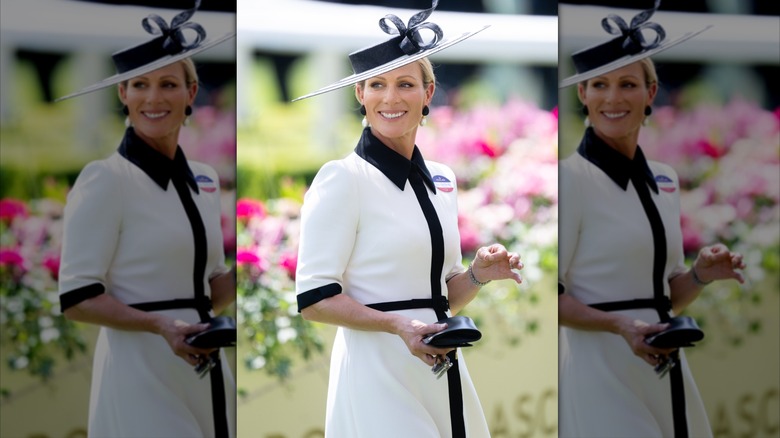 Zara Tindall in white dress with black trim and collar and a wide brimmed black and white hat