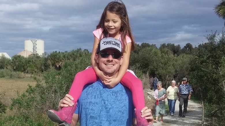 Brian Kleinschmidt holding Jade on his shoulders