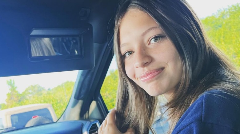 Jade smiling in the passenger seat of a car