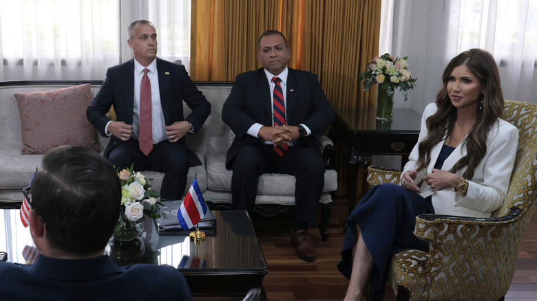 Corey Lewandowski stares at Kristi Noem as they sit in a meeting with the president of Costa Rica
