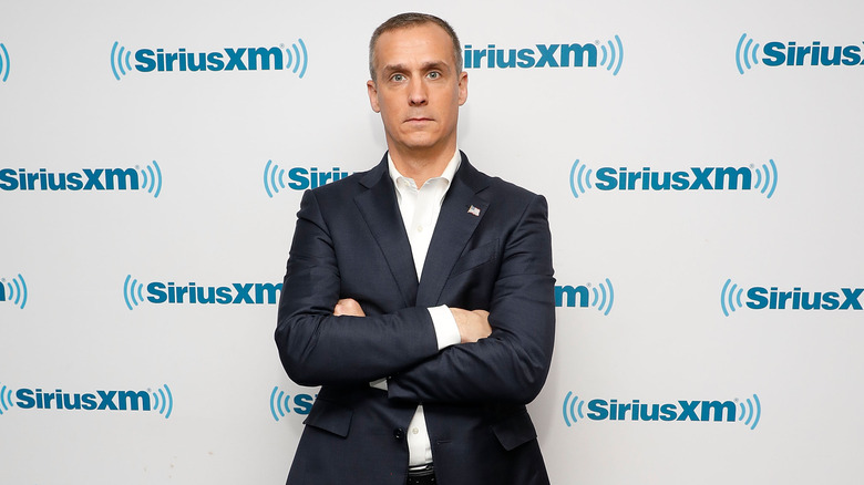 Corey Lewandowski posing on SiriusXM step-and-repeat with his arms folded