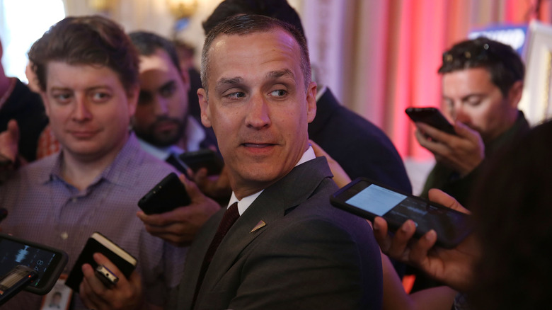 Corey Lewandowski surrounded by reporters