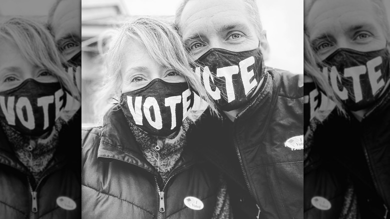 Kelly and Clint harp pose in a selfie wearing masks that say "vote" on election day