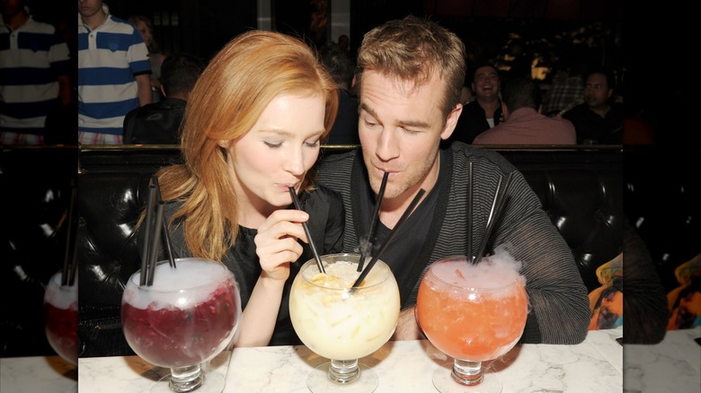 Kimberly Van Der Beek and James Van Der Beek sharing drinks