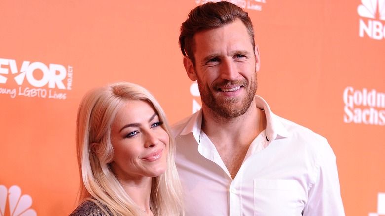 Julianne Hough and Brooks Laich on an orange step-and-repeat