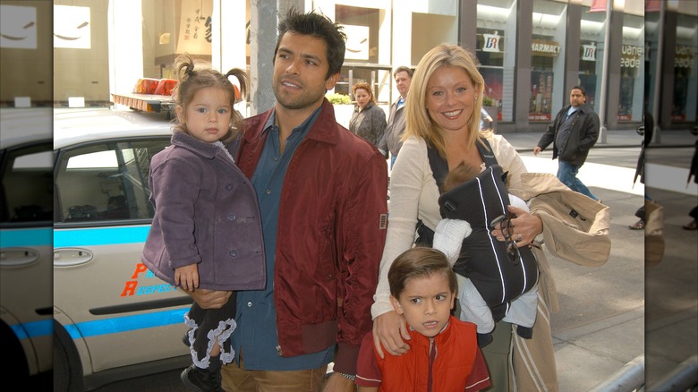 Mark Consuelos and Kelly Ripa posing with their three children