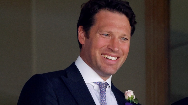Lt. Col. Jonny Thompson smiling, wearing a flower in his lapel