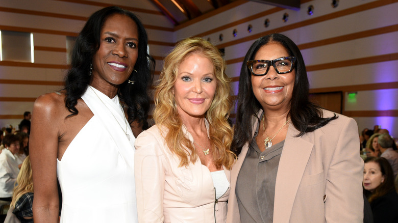 Cookie Johnson in smart dress smiling with friends