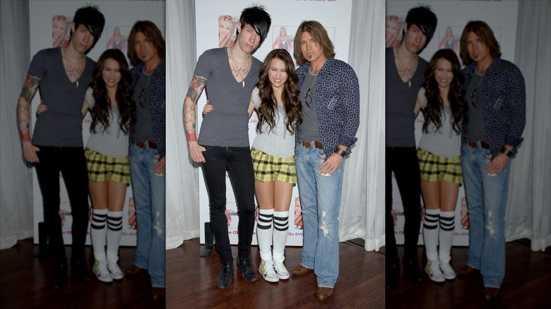 Trace Cyrus, Miley Cyrus, and Billy Ray Cyrus posing at a Hannah Montana event