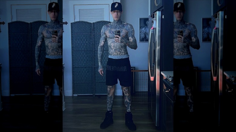 Trace Cyrus taking a mirror selfie that shows off his tattooed chest