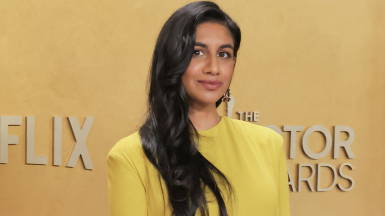 Monica Padman smirking wearing yellow dress