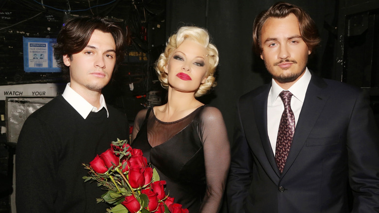 Dylan Jagger Lee, Pamela Anderson, and Brandon Thomas Lee smiling at the opening night of "Chicago" on Broadway in 2022