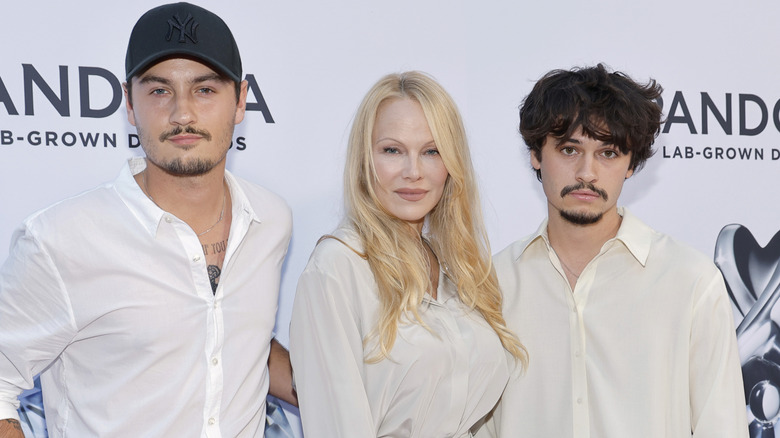Brandon Thomas Lee, Pamela Anderson, and Dylan Jagger Lee smiling at a Pandora event in 2023