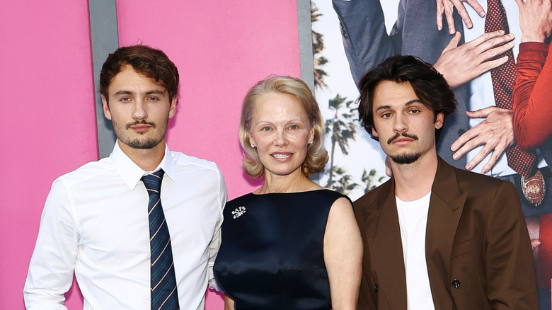 Pamela Anderson, Brandon Thomas Lee, and Dylan Jagger Lee posing at "The Naked Gun" premiere in 2025