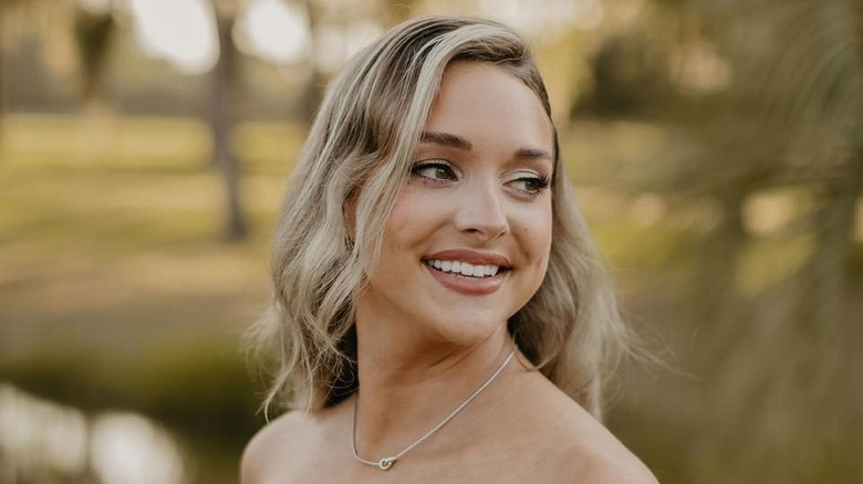 Morgan Doughty Bostick smiles with her head turned to the side looking over her shoulder outside.