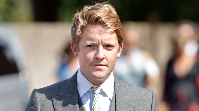 Hugh Grosvenor walking outside in suit