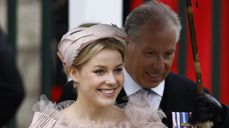 Lady Margarita Armstrong-Jones smiles as her father holds an umbrella behind her