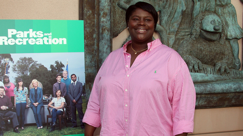 Retta posing with a Parks and Recreation poster