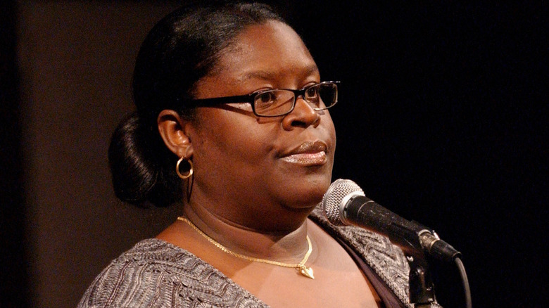 Retta performing onstage at a comedy club