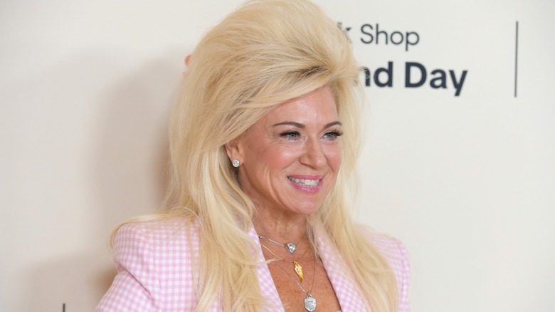 Theresa Caputo smiling in a pink gingham suit