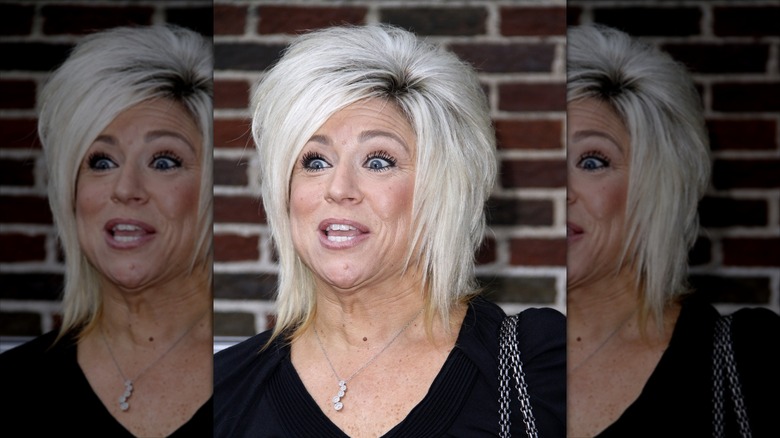 Theresa Caputo looking like she's yelling in front of a brick wall